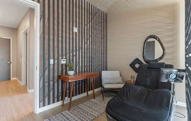 a salon room with a black chair and a mirror
