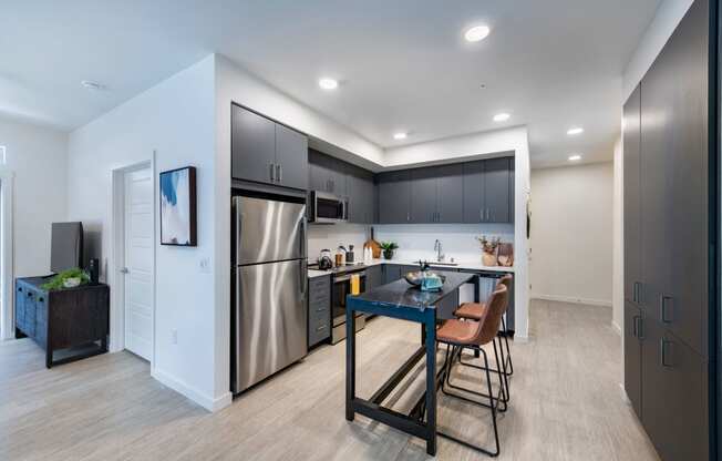 a kitchen with stainless steel appliances and a table with chairs