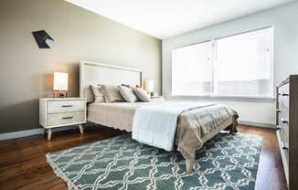 Model bedroom with hardwood floors and large windows
