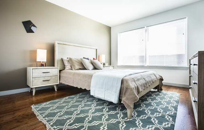 Model bedroom with hardwood floors and large windows