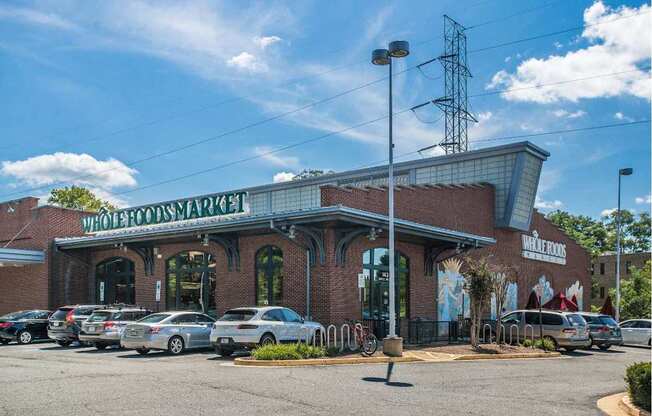 A Whole Foods Market store with cars parked in front.