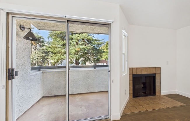 A room with a fireplace and sliding glass doors.