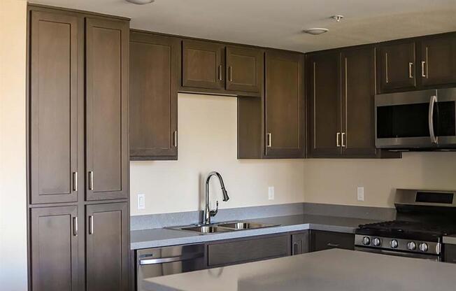 kitchen with a sink a stove and a microwave at Loma Villas Apartments, California