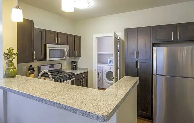 A kitchen with a stove, microwave, and refrigerator.