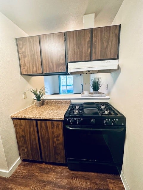 a kitchen with a stove and cabinets and a counter