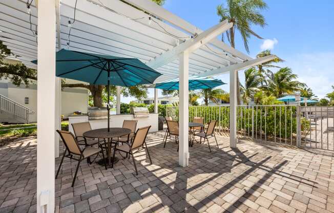 a patio with tables and chairs and umbrellas