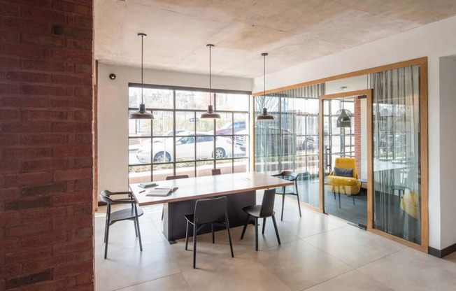 a dining room with a table and chairs in front of a window