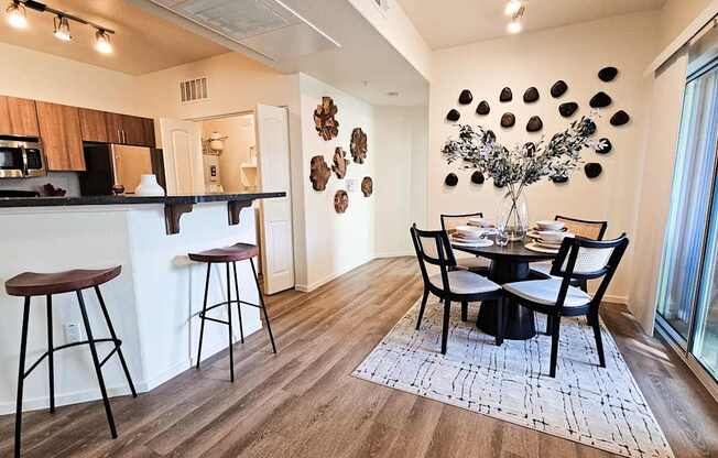 A modern kitchen with a dining table set for four.