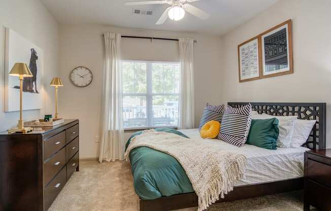 an open bedroom with a bed and a ceiling fan