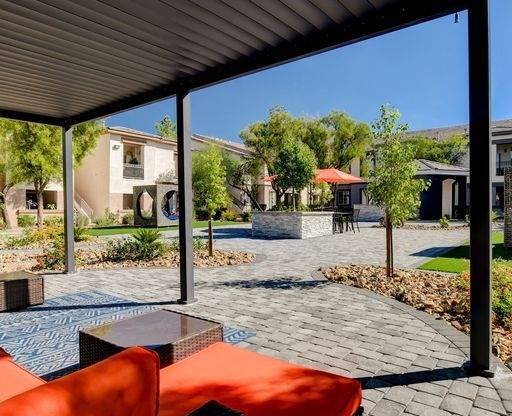 A patio with a table and chairs is covered by a roof.