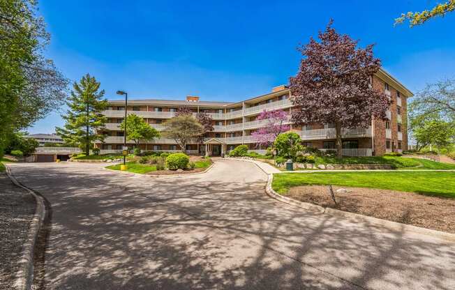 A large apartment complex with a paved driveway in front.
