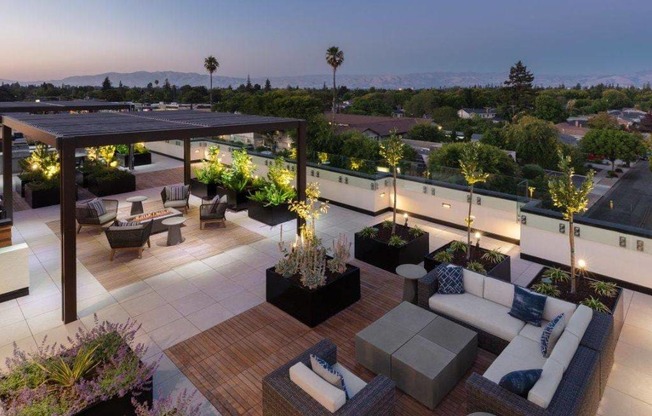a roof top patio with furniture and a view of the city