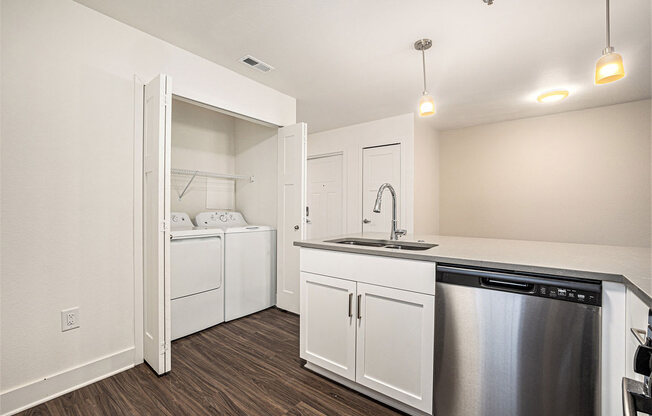 a kitchen with a washer/dryer and a stainless steel dishwasher  at Signature Pointe Apartment Homes, Athens