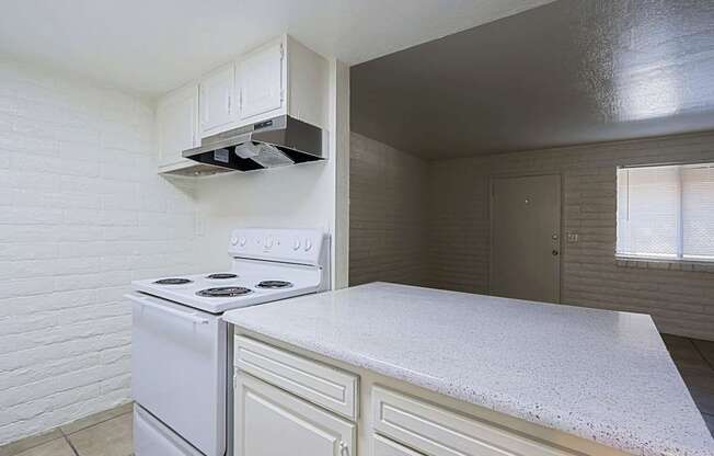 A white stove is in a kitchen with a white counter.