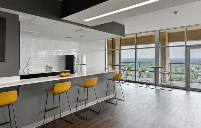 a kitchen with a long counter and yellow bar stools