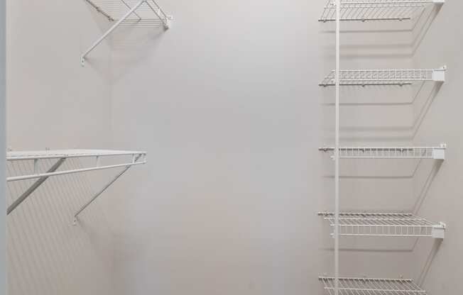 a spacious closet in a small room with white walls and shelves