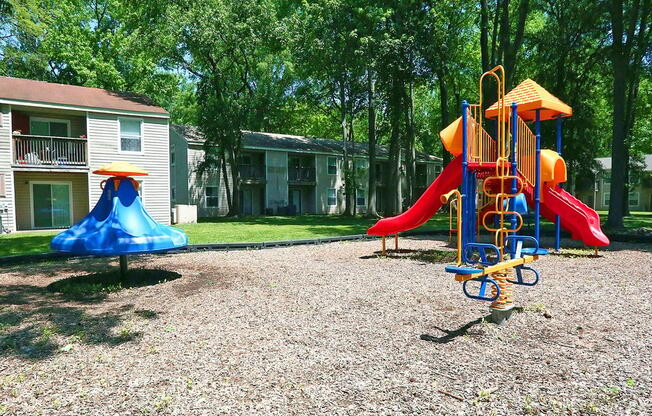 a playground with slides and swings in a yard