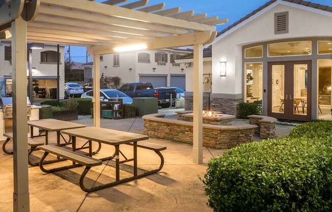 A patio with a picnic table and a fire pit.