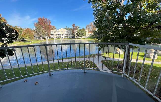 A balcony overlooks a body of water with a building in the background.