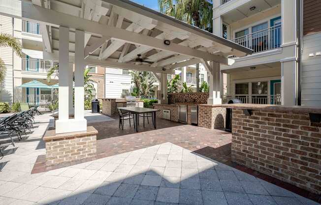 A patio with a table and chairs under a roof.