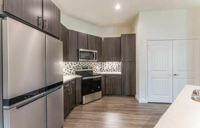 Kitchen With Black Cabinetry And Modern Appliances at Residences at 3000 Bardin Road, Grand Prairie, 75052