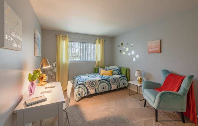 a bedroom with a bed and a desk and a chair