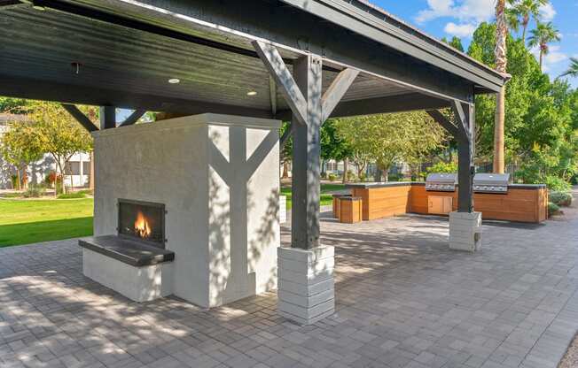 the outdoor pavilion has a fireplace and a picnic table