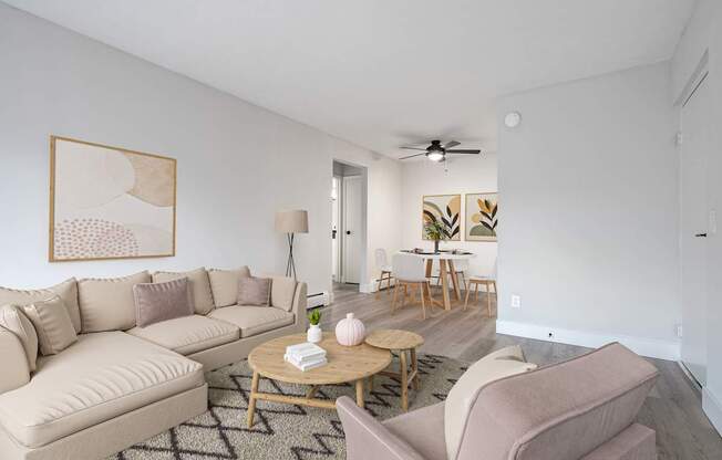 A living room with a beige couch, a coffee table, and a painting on the wall.