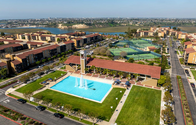 an aerial view of a swimming pool in the middle of a park and a city