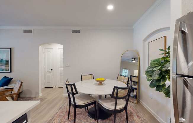a dining room with a white table and black chairs