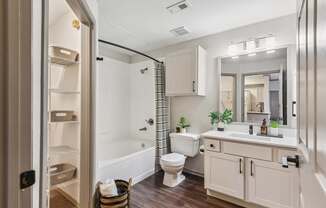 A bathroom with a toilet, sink, and mirror.