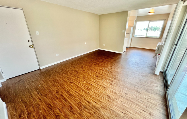 Bright and airy living space with stylish wood flooring, large windows, and an open layout perfect for modern living.