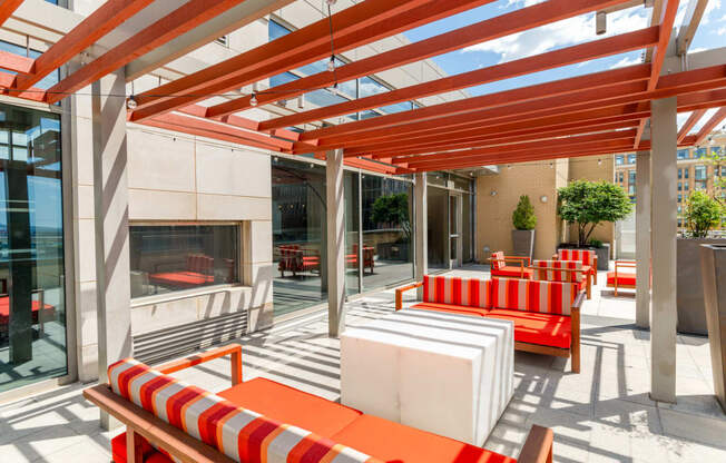 a patio with orange and white furniture and a fireplace