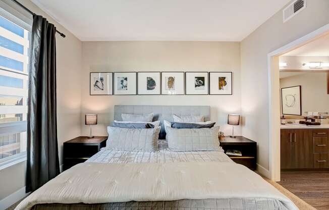 a bedroom with a bed and framed pictures on the wall