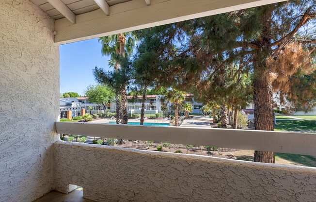 a balcony with a view of a tree and a pool
