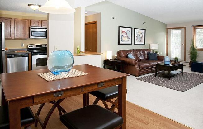 Dining room and living room areas with a large leather couch and a rectangular brown table