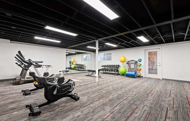 a workout room with exercise equipment and weights in a building with white walls and carpet at Talavera in Boise, ID