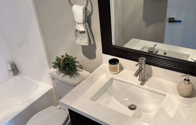 a bathroom with a sink toilet and a mirror