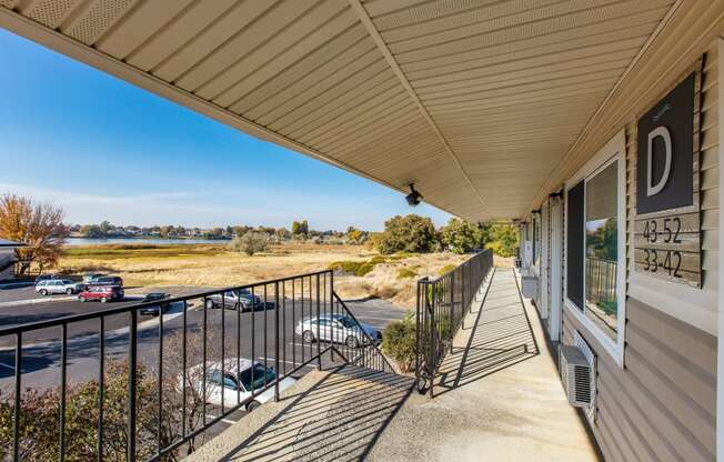 the front porch of a house with a balcony and a view of a parking lot