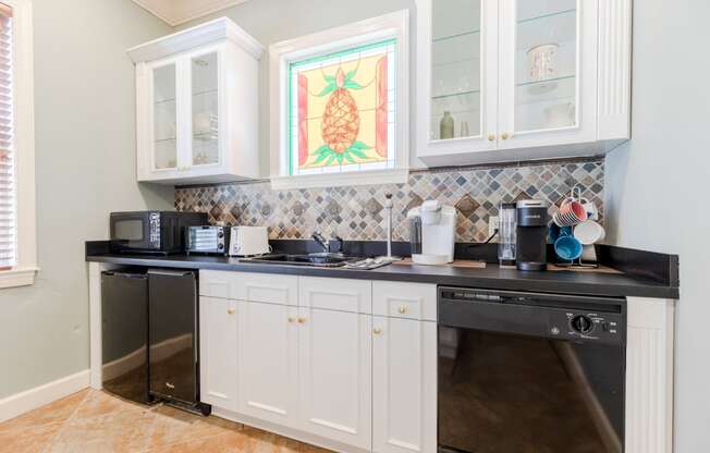 a kitchen with white cabinets and a black counter top at Heritage Bay, Jensen Beach, FL 34957