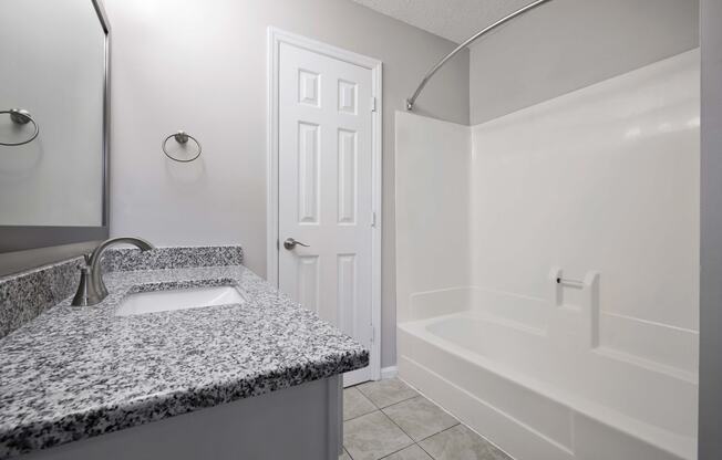 Bathroom with granite counter tops and bath tub