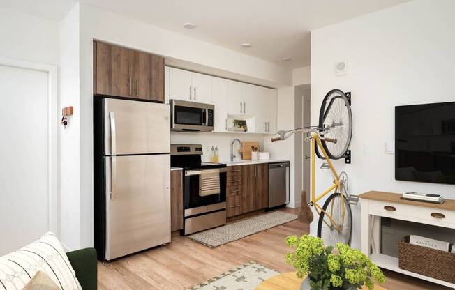 a kitchen with stainless steel appliances and a bike in a living room