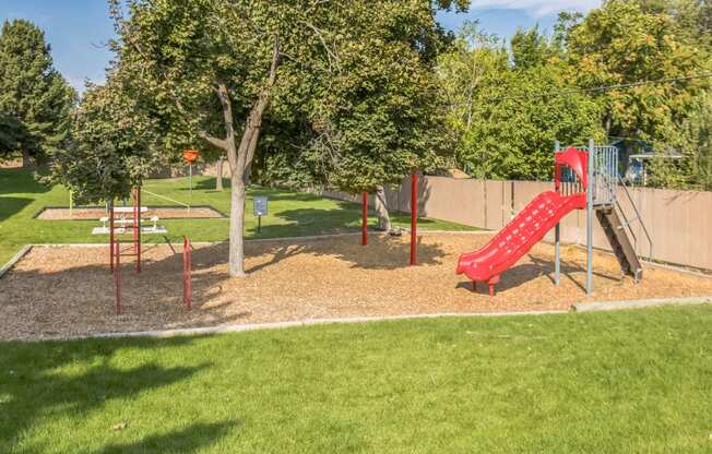 a playground at a park with a red slide