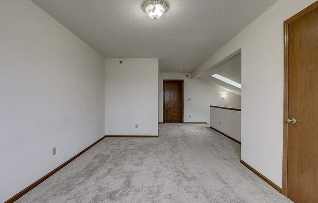 an empty living room with white walls and a wooden door