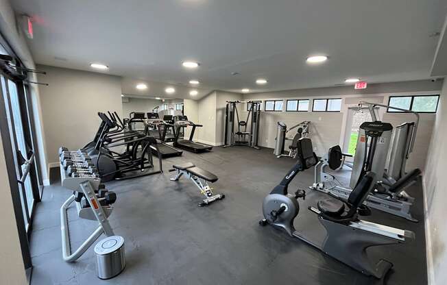 A gym with a variety of equipment including treadmills, weights, and exercise machines.
