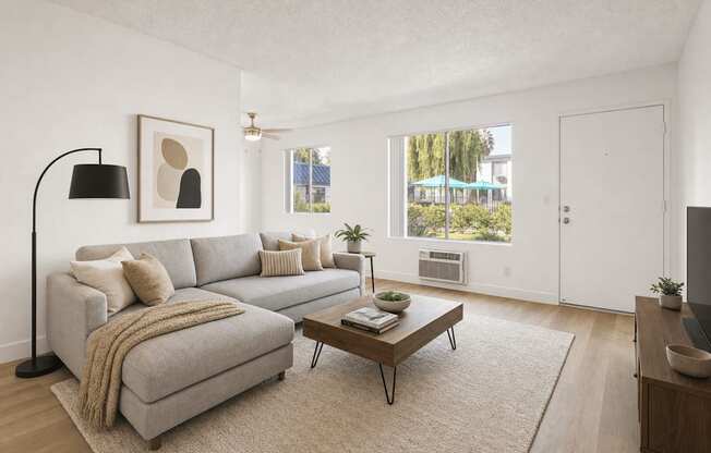 A living room with a grey couch, a coffee table, and a lamp.