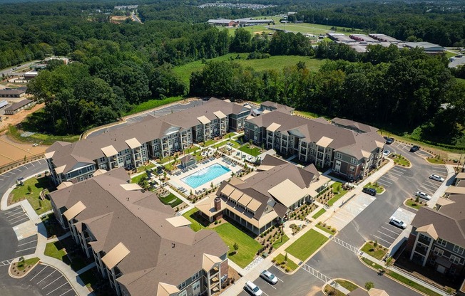 an aerial view of a hotel and apartments with a swimming pool