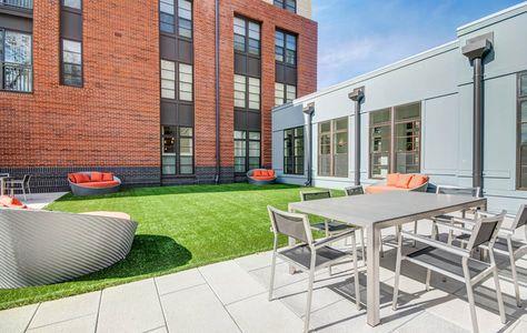 a patio with a table and chairs in front of a building