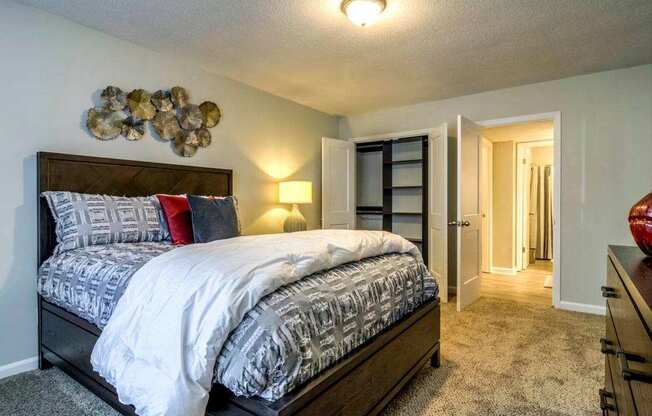 A bedroom with a large bed and a wall decoration.