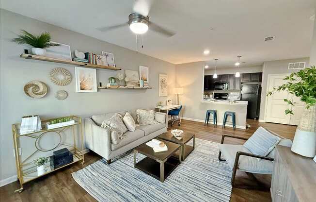 A living room with a white couch, a coffee table, and a ceiling fan.